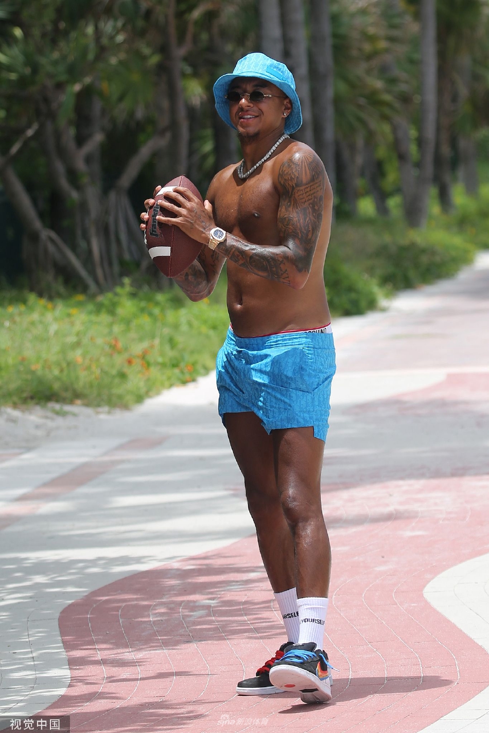 曼城球星斯特林休赛期现身迈阿密度假 赤膊出街把玩美式橄榄球（斯特林是曼城几号）