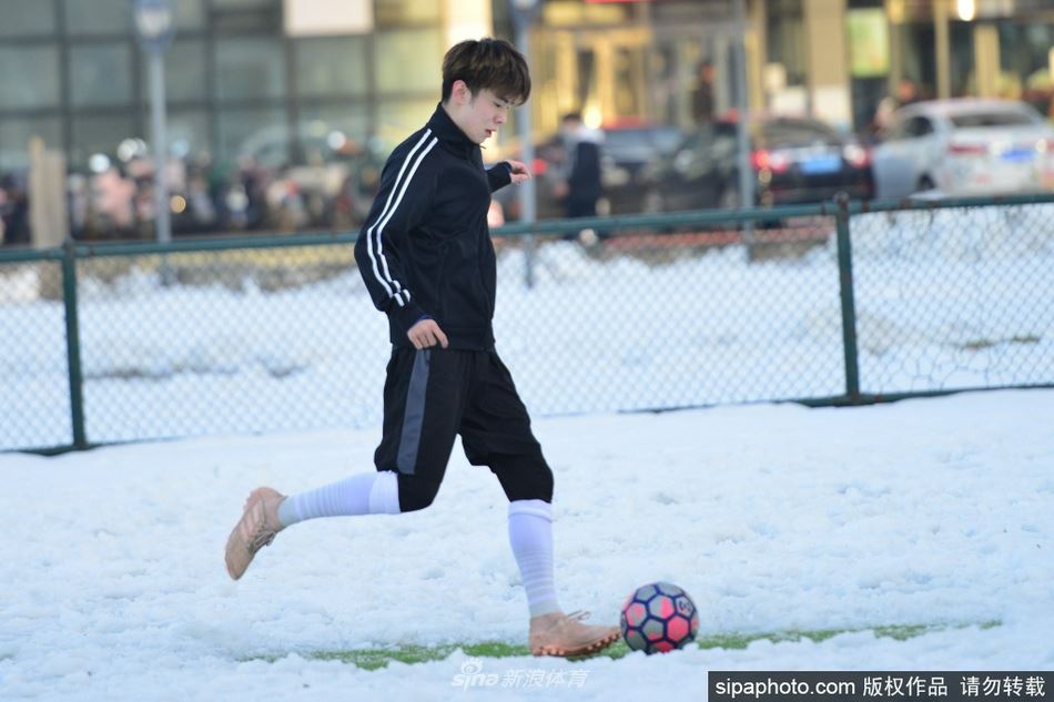 暴雪过后青少年雪地练习踢足球不惧严寒秀球技（雪地里踢足球）