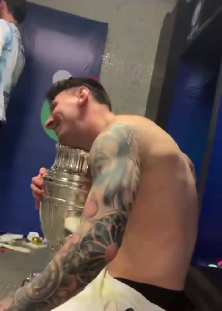 开心得像个孩子！梅西抱着冠军奖杯合影爱不释手（梅西看着奖杯）